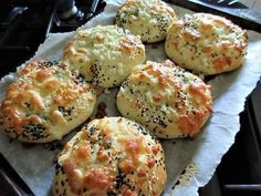 six biscuits with poppy seed sprinkles sitting on top of a piece of parchment paper