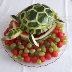 a turtle made out of watermelon, grapes and melons on a plate