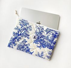 a blue and white bag with an apple laptop on it's lap top cover