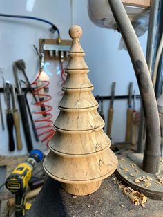 a wooden christmas tree sitting on top of a piece of wood next to tools and wires