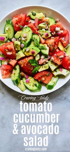 a white plate filled with cucumber and tomato salad on top of a table