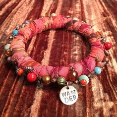 a close up of a bracelet on a table with beads and charms attached to it