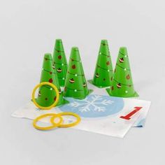 small green christmas trees with scissors on top of paper and some other items in front of them