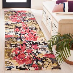 a living room area with a rug, plant and window