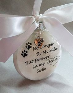 a white ornament with a dog's paw on it and a ribbon