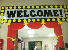 a welcome sign in front of a door with red and yellow decorations on the outside