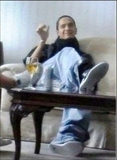 a man sitting on top of a couch next to a table