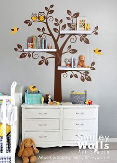 a baby's room with a tree wall decal