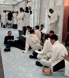 a group of people in white lab coats sitting on the floor next to each other