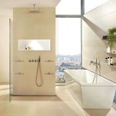 a bathroom with a tub, sink and shower head in front of a large window