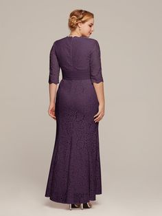 a woman in a long purple dress is looking down at the back of her gown