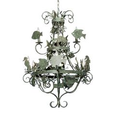 a metal chandelier hanging from the ceiling with birds and flowers on it's sides