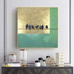 three birds are sitting on a wire in front of a green and gold wall art