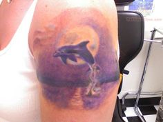 a woman with a dolphin tattoo on her arm