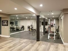 an empty gym with mirrors and equipment in the middle, including treadmills and exercise machines