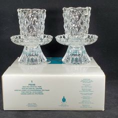 two crystal candlesticks sitting on top of a box