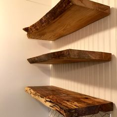 three wooden shelves are hanging on the wall