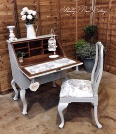 a white desk with a chair next to it and a birdcage on top