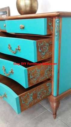 an old dresser has been painted blue and gold with intricate designs on the top drawers