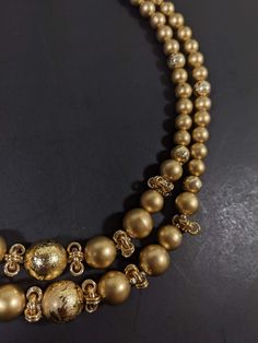 This vintage necklace has 2 strands of gold tone beads. It measures 18 inches long with a hook style clasp. It has only very light wear. R Elegant Gold Layered Necklace With Beaded Chain, Gold Multi-strand Jewelry With Polished Beads, Gold Layered Necklace With Round Beads, Gold Double Strand Polished Beads Jewelry, Gold Round Beaded Necklaces For Party, Gold Multi-strand Jewelry With Spacer Beads, Gold Multi-strand Layered Necklace With Beads, Gold Beaded Necklaces With Polished Beads For Party, Gold Multi-strand Necklace With Gold Beads