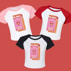 three children's t - shirts with pink and red sleeves, one in the shape of a book