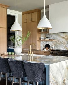 Designed by Nashville-based @jfy.designs. Along with statement-making marble surfaces, a minimalistic range hood keeps the focus on all the thoughtful organic accents. Underneath the island, a decorative fluted panel offers a playful contrast in blue. Overhead, our bell-shaped Agnes Medium Pendants by AERIN add a mid-century modern style. Waterfall Kitchen Island, Waterfall Island Kitchen, Waterfall Kitchen, Fluted Panel, Gold Lighting, Gas Lanterns, Over The Sink, Recessed Downlights, Circa Lighting