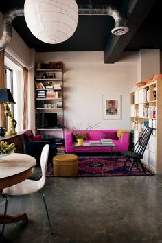 a living room filled with furniture and lots of bookshelves on top of it