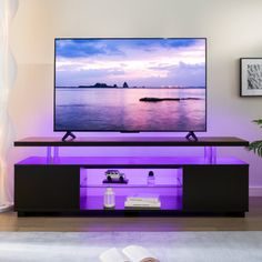 a flat screen tv sitting on top of a wooden stand