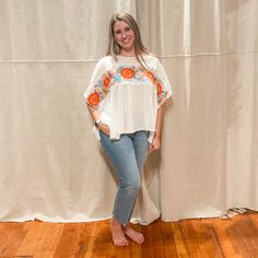 "Add a burst of color to your wardrobe with our Embroidered Flower Breezy Top. Featuring bright embroidered flowers on a white background, this poncho style top is perfect for any occasion. Embrace the playful and quirky side of fashion with this unique piece." Poncho Style Top, Burst Of Color, Poncho Style, Embroidered Flowers, Unique Pieces, White Background, Wardrobe, Flowers, White