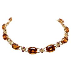 Semi-rigid choker necklace made in yellow gold with large oval-cut quartz (Citrines) alternating with intertwined links centered by two cabochon-cut rubies and two brilliant-cut diamonds. The necklace can be divided into two bracelets and a pendant. Approx. weight of stones: Quartz: 115,00 cts Diamonds: 1,60 cts, colour H, clarity VVS, Rubies: 4,00 cts 1950s Luxury Orange Necklace With Natural Stones, Luxury Vintage Antique Gold Necklace, Formal Citrine Necklace With Oval Shape, Oval Citrine Necklace For Formal Occasions, Drink Outfit, Orange Quartz, Hand Jewelry Rings, Quartz Choker, Choker Necklace Gold