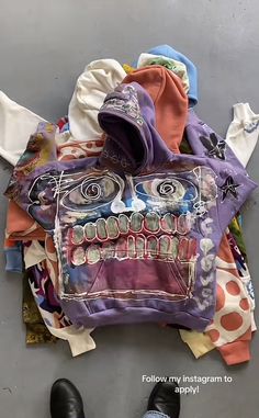 a pile of clothing and shoes laying on the floor next to each other with faces painted on them