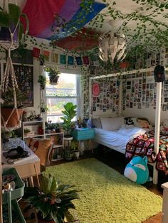 a bedroom with plants hanging from the ceiling and lots of pictures on the walls above it