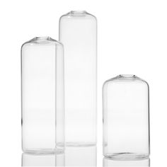 three clear glass vases sitting next to each other