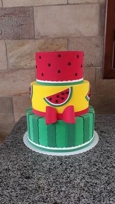 a three tiered cake with watermelon slices on it