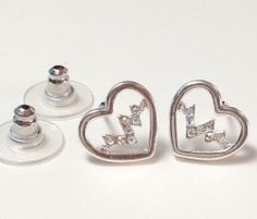 two heart shaped earrings sitting next to each other