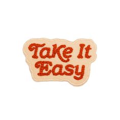 a patch with the words take it easy in red and orange glitters on it