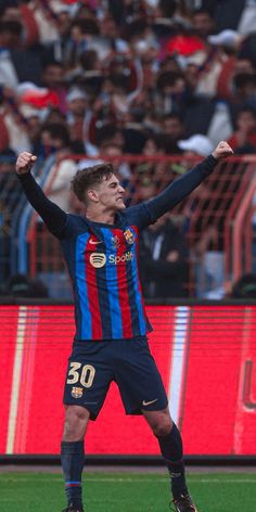 a soccer player is celebrating his goal in front of an empty stadium full of fans