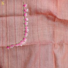 pink and white flowers are embroidered on an orange linen material that has been stitched into the fabric