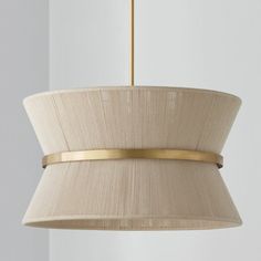 a beige lamp hanging from a ceiling with a white wall in the backround