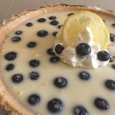 a lemon and blueberry cheesecake with whipped cream on top, garnished with fresh blueberries