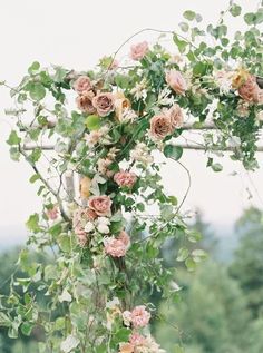 an outdoor wedding arch with flowers and greenery