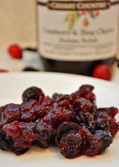 a white plate topped with raisins next to a bottle of wine