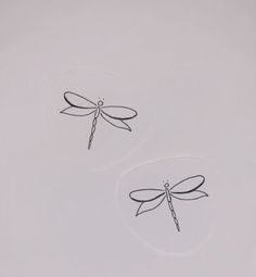 two stickers with dragonflies drawn on them