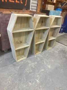 three wooden shelves sitting next to each other on top of a cement floor in a garage