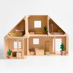 a doll house with all the furniture and accessories made out of wood, including plants