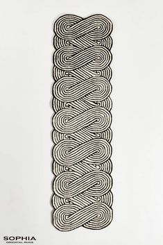 an intricately designed wall hanging on the side of a white wall with black and white lines