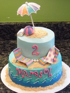 a birthday cake with an umbrella and beach ball on top