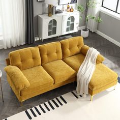 a living room with a yellow couch and white rug