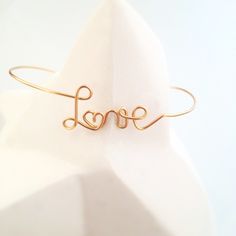 This bangle bracelet is made, to order, by me in my workshop in Beaujolais ⛰️ . I make each jewel with meticulousness and quality materials.  Your bracelet is delivered, packed in a square of washed linen and in its FSC® certified kraft case made in Europe 🇪🇺.  🌈 Personalization 🌈  ■ the personalized message includes up to 9 letters (possibility to include an & or a ♥)  ■ Only the first letter can be lowercase or uppercase, you can specify your choice per message. → By default, first names are capitalized, common words are lowercase (except Love)  ■ All other letters are lowercase.  → For a word in all capitals, contact me for a quote  ■ I can make a heart instead of an o. Ideally replace it with a heart emoji or copy/paste this one: ♥ ■ I can add a heart before or/and after your messa Minimalist Name Bangle Bracelet For Wedding, Minimalist Rose Gold Name Bracelet For Wedding, Gold Handmade Name Bracelet For Anniversary, Minimalist Handmade Wedding Bracelets, Handmade Gold Name Bracelet For Wedding, Handmade Minimalist Wedding Bracelets, Minimalist Name Bracelets For Wedding, Gold Name Bangle Bracelet For Wedding, Dainty Name Bangle Bracelet For Wedding