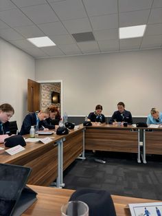 a group of people sitting at desks in an office